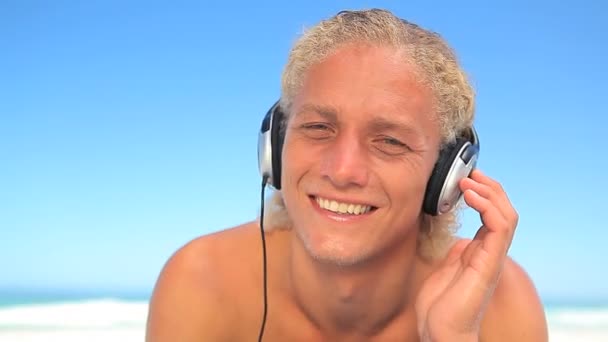 Blonde man listening to music with headphones — Stock Video