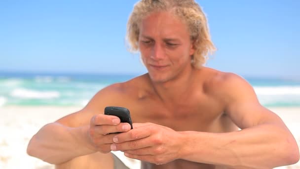 Улыбающийся блондин пользуется телефоном. — стоковое видео