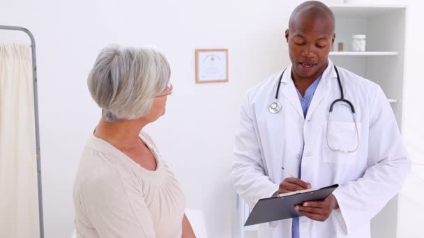 Sorridente medico parlando con una donna matura — Video Stock