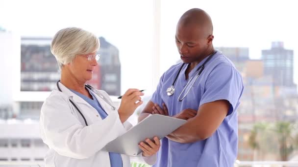 Ciddi olgun doktor ile hemşire konuşuyor — Stok video