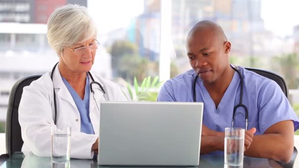 A doctor and a nurse looking at a laptop — Stock Video