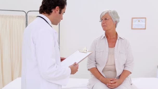 Улыбающаяся пациентка разговаривает со своим практикующим — стоковое видео