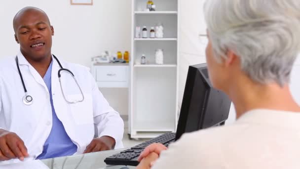 Mature woman explaining her pain to a doctor — Stock Video