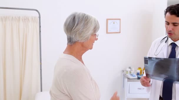 Doctor showing an x-ray to her patient — Stock Video