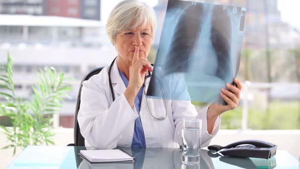 Médico reflexivo sosteniendo una radiografía — Vídeo de stock