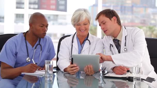 Equipo médico serio mirando una tableta — Vídeos de Stock