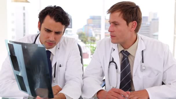 Serious doctors looking together at an x-ray — Stock Video