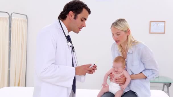 Medico serio che mostra una siringa per un bambino — Video Stock