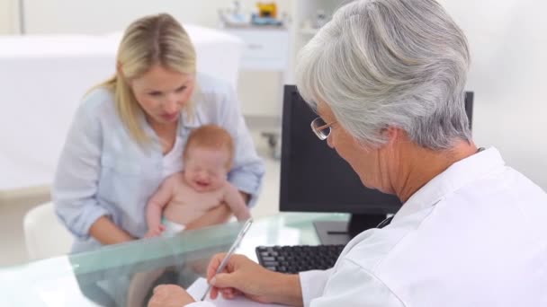 Ärztin bewegt ihre Finger vor einem Baby — Stockvideo