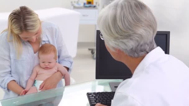 Médico sorridente conversando com uma mãe — Vídeo de Stock