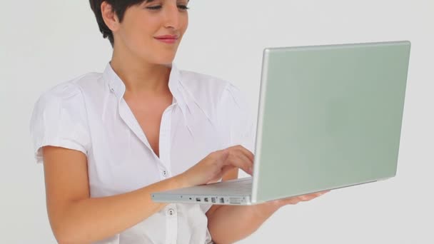 Businesswoman holds a laptop as she types on it — Stock Video