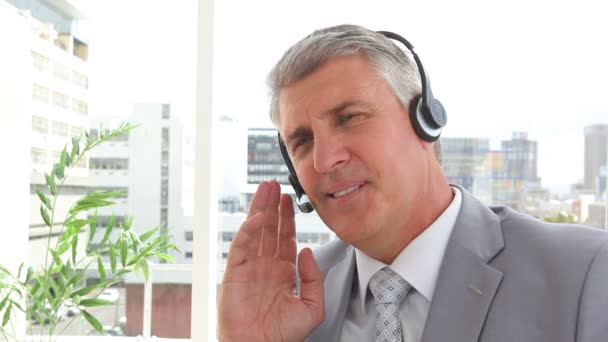 Homem de negócios falando em um fone de ouvido — Vídeo de Stock