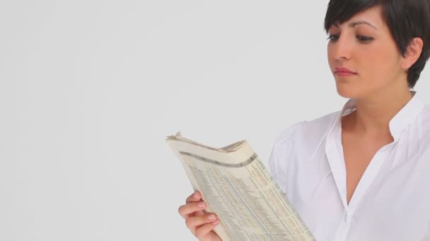 Businesswoman nods as she reads a newspaper — Stock Video