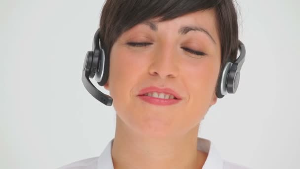Bir kulaklık konuşurken gülümseyen iş kadını — Stok video