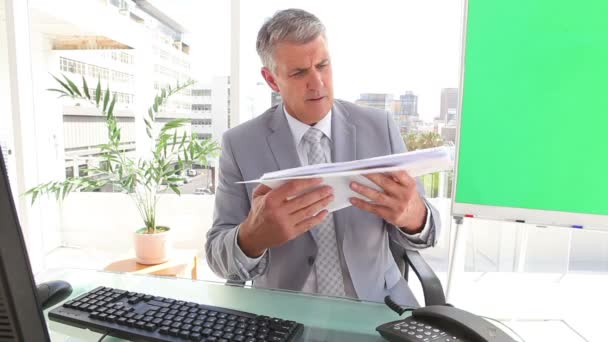 Homme d'affaires regardant des pages de statistiques — Video