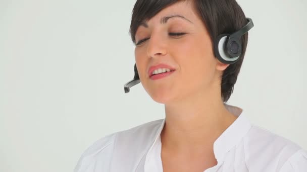 Mujer de negocios felizmente hablando a través de un auricular — Vídeos de Stock