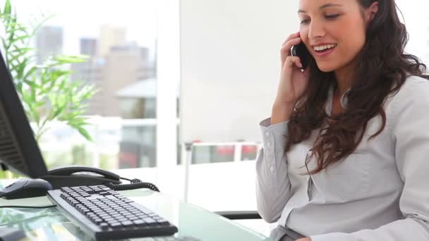 Businesswoman smiles as she answers a phone — Stock Video