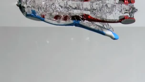 Toothbrushes in a super slow motion falling — Stock Video