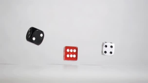 Drie zwarte rode witte dobbelstenen in een super slow motion rebonding — Stockvideo