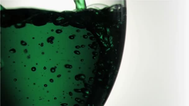 Grünes Rinnsal in Superzeitlupe, das ein Glas füllt — Stockvideo