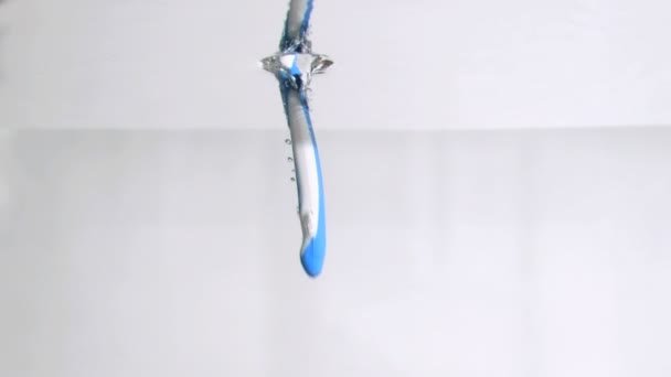 Een blauwe tandenborstel in een super slow motion verticaal vallen in water — Stockvideo