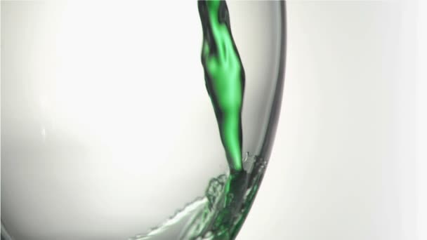 Close up, green trickle in a super slow motion splashing in a glass — Stock Video