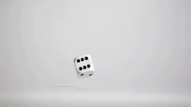 En vit tärning i super slow motion rebonding på golvet grå — Stockvideo
