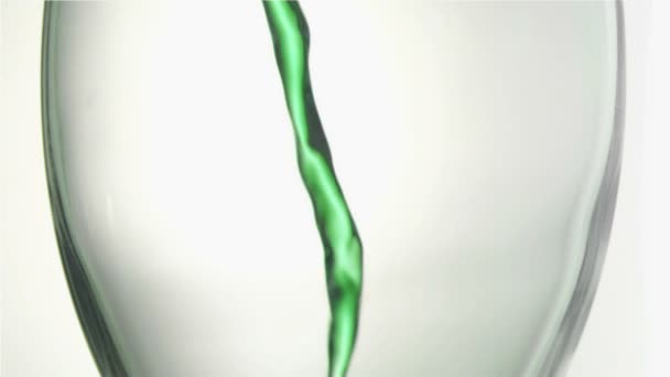 Зеленая жидкость в очень медленном движении, текущем в стакане — стоковое видео