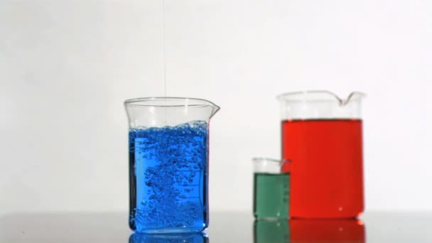 Burbujas en una cámara súper lenta moviéndose en un vaso de precipitados azul — Vídeo de stock