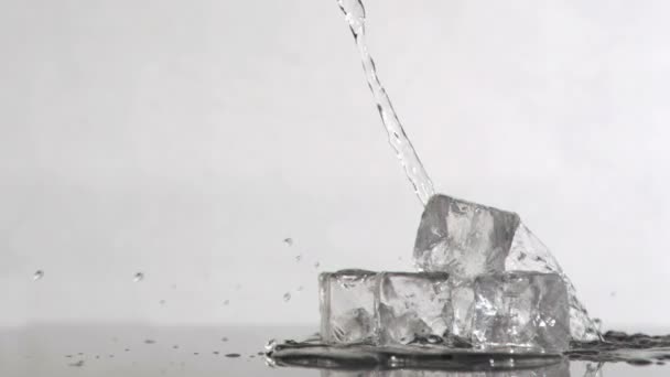 Agua cayendo en cámara súper lenta sobre cubos de hielo — Vídeos de Stock