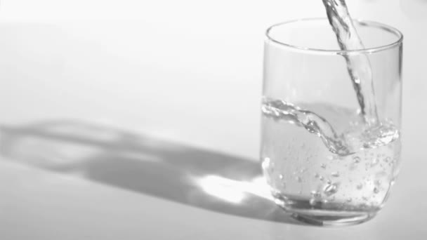 Water stroomt in super slow motion in een glas — Stockvideo