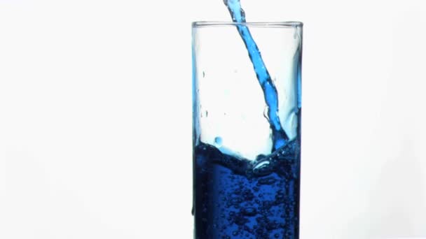 Blaue Flüssigkeit in Superzeitlupe, die in einem Glas am Rand überläuft — Stockvideo