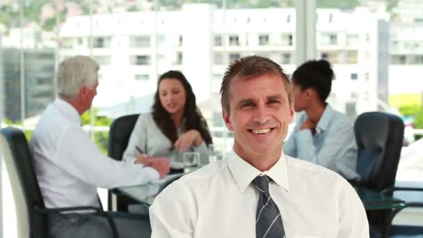 Portrait of a businessman with colleagues in meeting in background — Stock Video