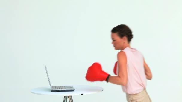 Businesswoman hitting a laptop with boxing gloves — Stock Video