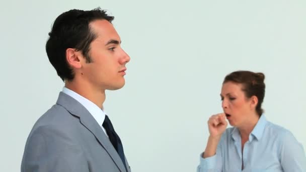 Man in suit wearing a surgical mask while a woman is sneezing — Stock Video