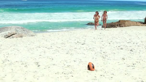 Un paio di donne in bikini che corrono verso una palla da rugby — Video Stock