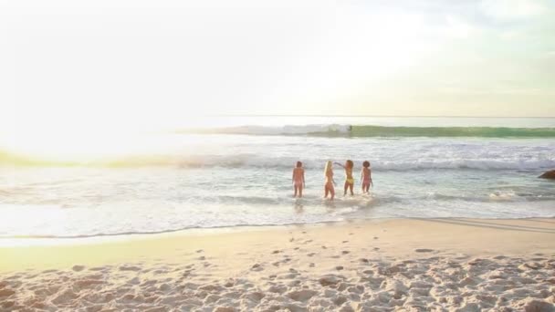 Четыре женщины идут по пляжу — стоковое видео