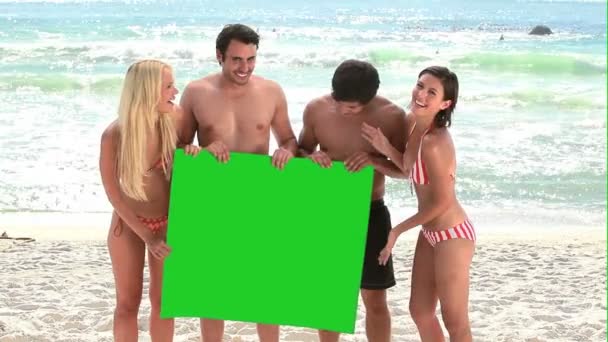 Fyra håller på en grön skärm — Stockvideo