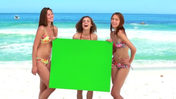 Kvinnor innehar en tom affisch medan skrattar — Stockvideo