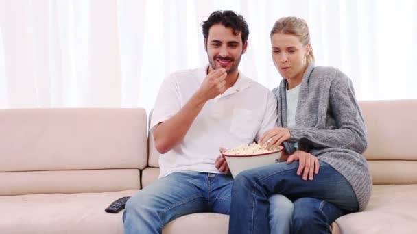 Pareja comiendo palomitas mientras ve una película — Vídeo de stock