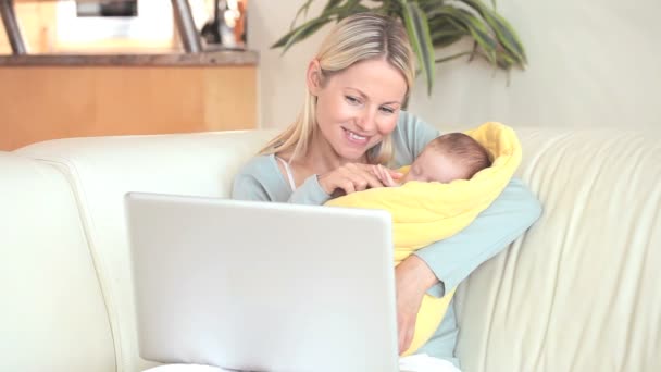 Mujer sosteniendo a un niño está haciendo una videollamada — Vídeo de stock