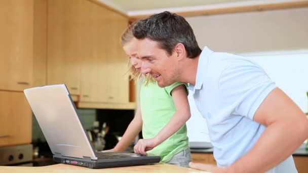 Hija usando un portátil mientras el padre está buscando — Vídeo de stock