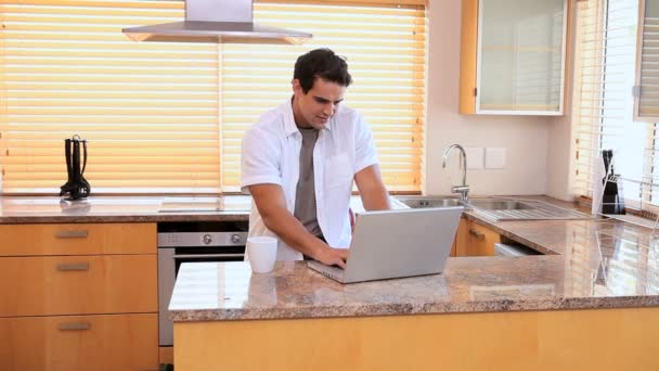 Mann benutzt Laptop und trinkt Kaffee — Stockvideo