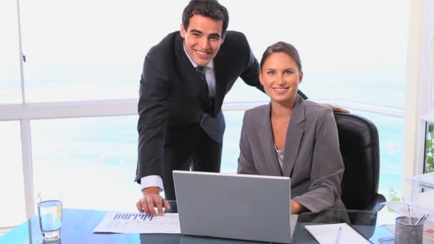 Empresario y mujer sonriendo a la cámara — Vídeo de stock