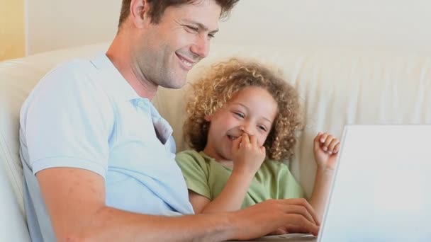 Padre con suo figlio in ginocchio usando un computer portatile — Video Stock