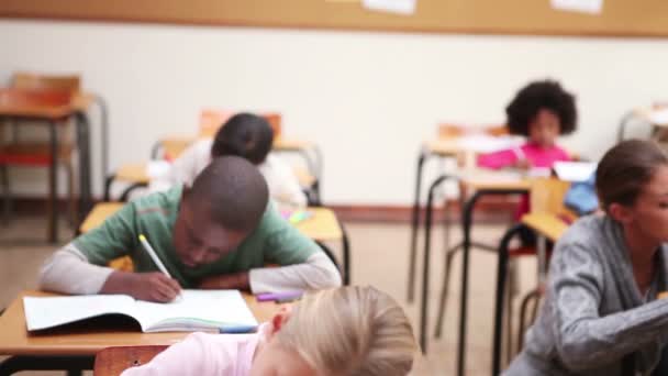 Alumnos serios escribiendo en sus cuadernos — Vídeos de Stock