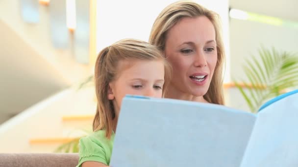 Mother reading a story to her blonde daughter — Stock Video