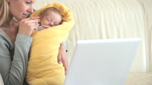 Femme faisant un appel vidéo tout en tenant son bébé — Video