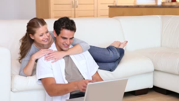 Woman embracing her boyfriend using a laptop — Stock Video