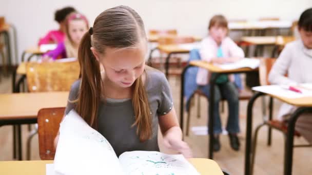 Lächelnde Schülerin blickt auf ihr Notizbuch — Stockvideo